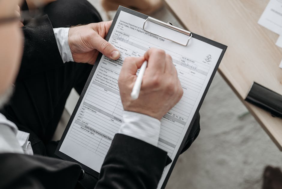 Close-up of hands holding a clipboard with insurance paperwork and a phone showing a calendar app, suggesting someone organizing care logistics