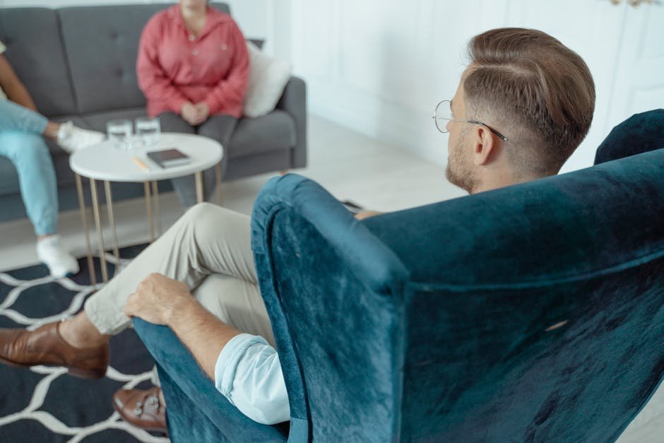 Family therapy session with parents and teenager seated with a clinician in a warm office setting, conveying collaborative treatment planning
