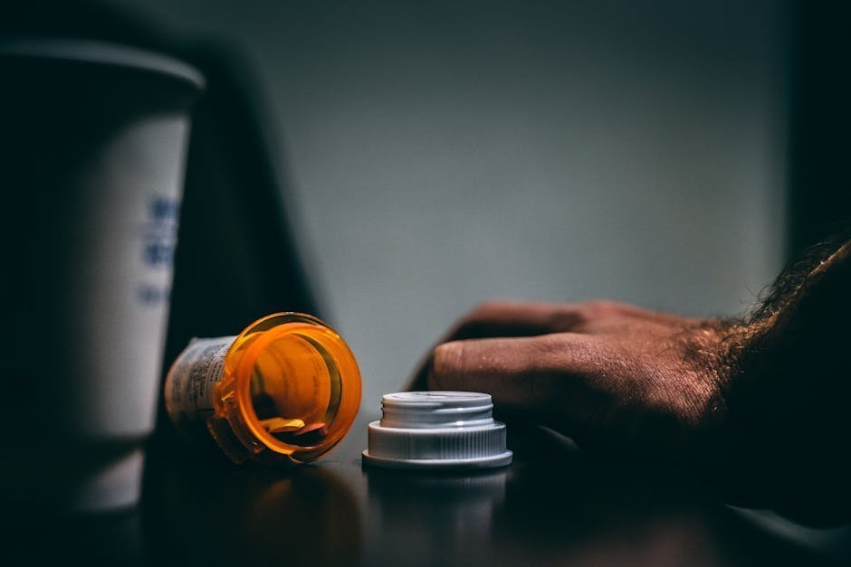 Person at home holding a prescription bottle and water glass, calm domestic setting with morning light, conveying medication adherence and recovery routine