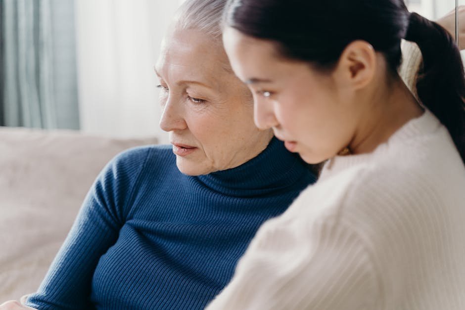 Senior woman with adult daughter in hospital memory clinic waiting room with educational pamphlets