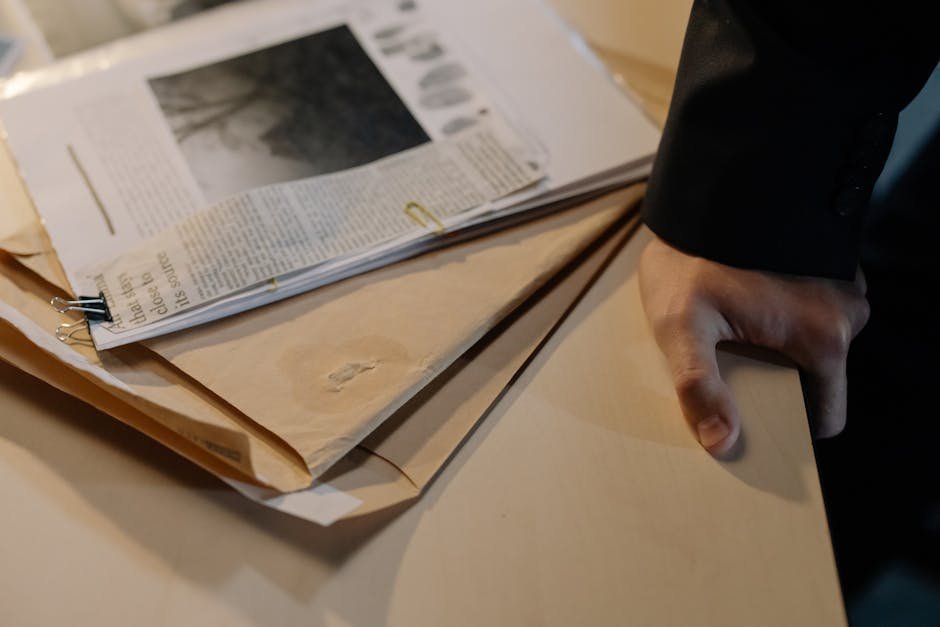 Stack of legal case files and discovery documents on attorney desk with reading glasses