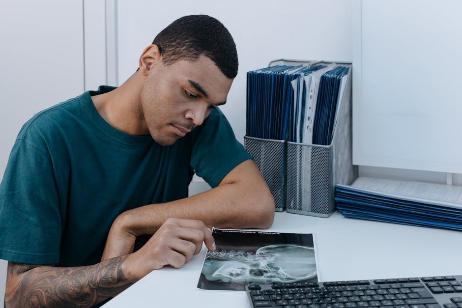 Person organizing medical records, denial letters, and appeal documents in folders for legal review