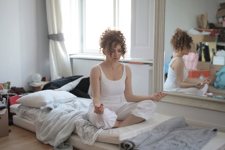 Morning routine for mental health stretch: a person doing a gentle stretch on a yoga mat in a sunlit bedroom, the small movement anchor that strengthens a morning routine for mental health