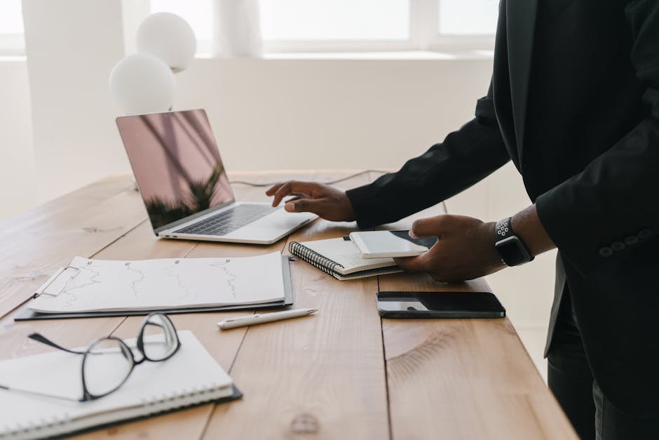 Open enrollment mental health planning at home: a calm desk with a laptop, plan documents, and a notebook, the everyday setup where most US households pick health coverage that will quietly determine therapy and psychiatry costs all year